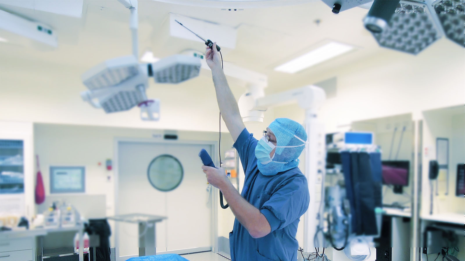 En man i blåa sterila kläder mäter luftkvaliteten i ett labb